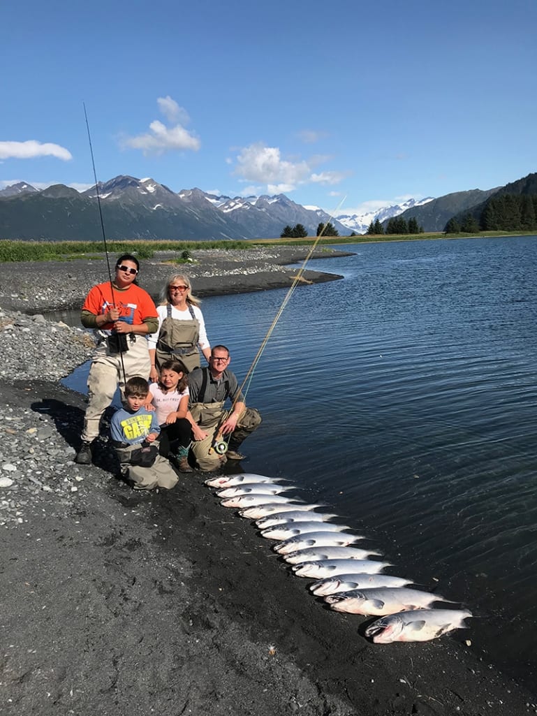 Family displaying their catch waterside