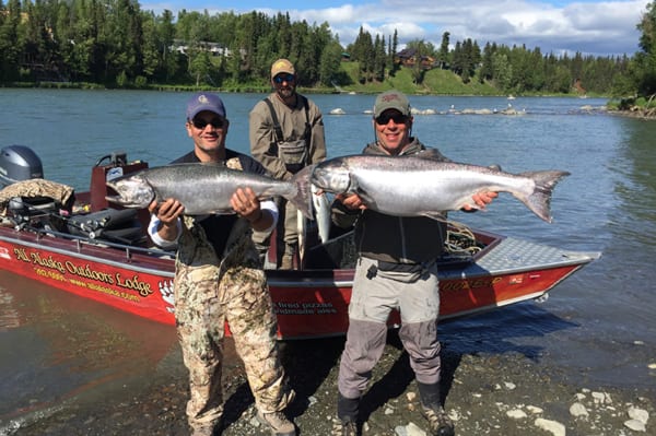 Two men each holding one large fish Two men each holding one large fish