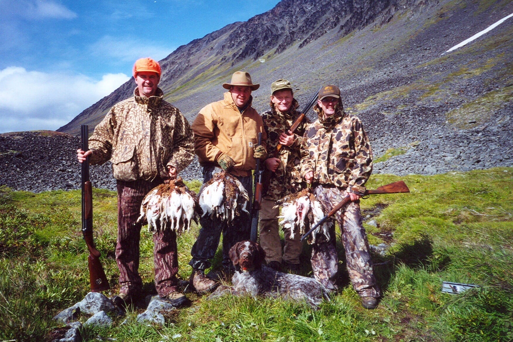 A group of people holding game they hunted