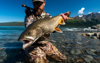 Another example of Lake Trout available in Alaska man displays the lake trout he just caught