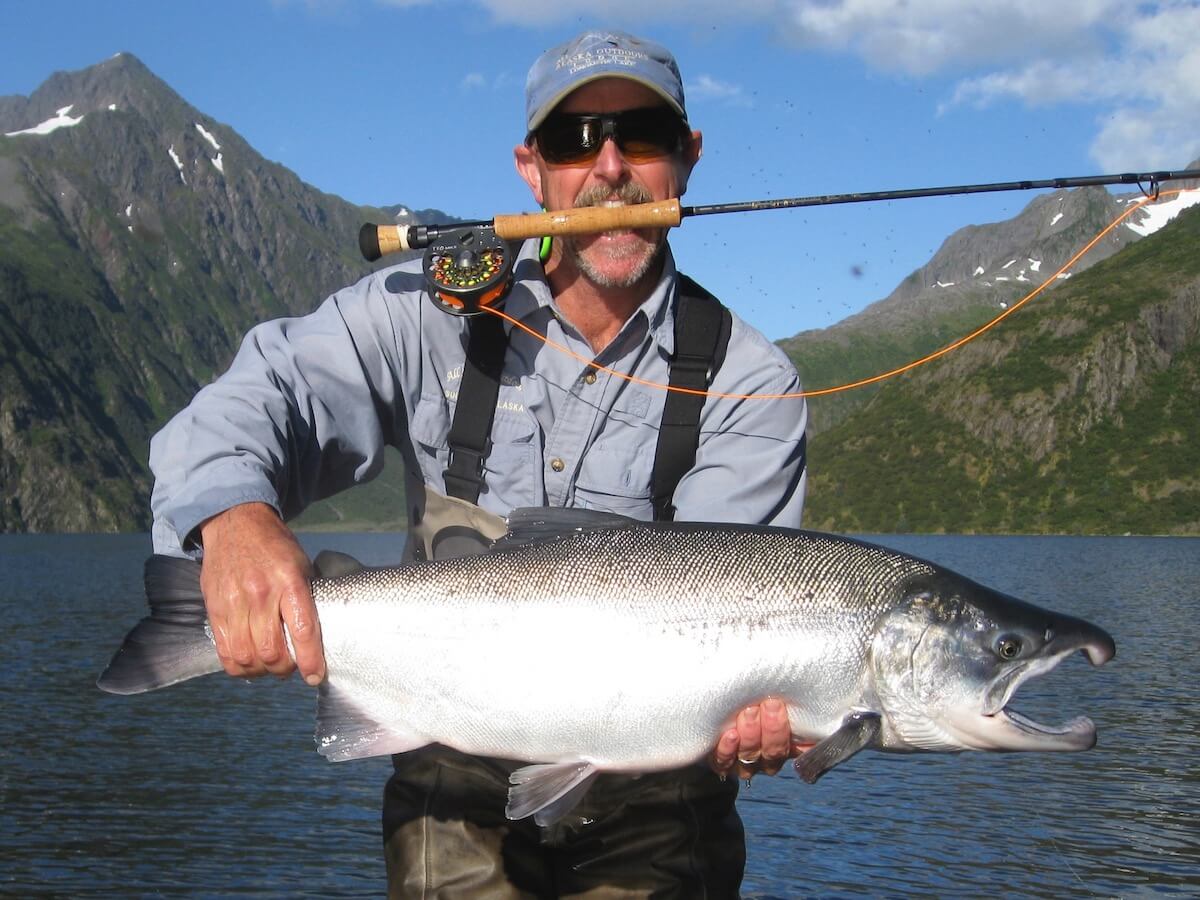 Dr. Bob Ledda Dr. Bob Ledda holding his fly rod in his teeth while displaying his catch.