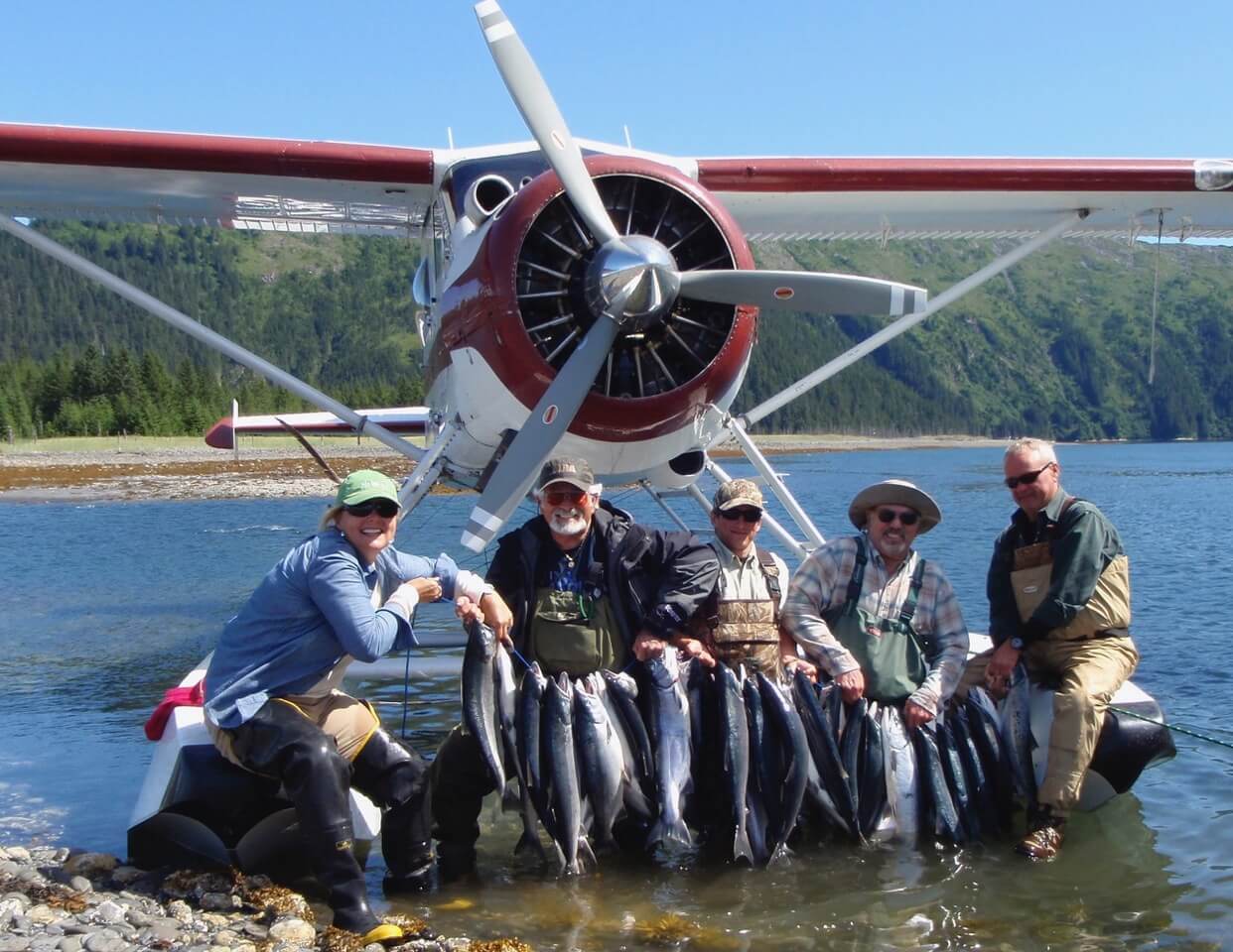 group-angler-posing-silver-salmon-fish-plane-bank-2022-3-17 A group of anglers displaying their catch of silver salmon in front of the plane.