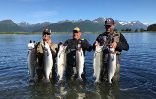 group-angler-posing-silver-salmon-fish-wade-2022-3-17 Three anglers posing in a stream with caught silver salmon