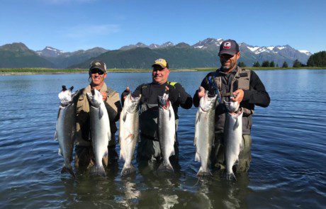 group-angler-posing-silver-salmon-fish-wade-2022-3-17 Three anglers posing in a stream with caught silver salmon