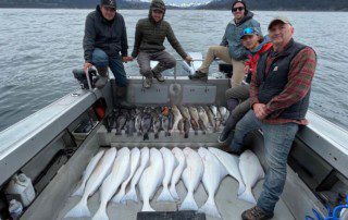 group-angler-posing-varied-fish-boat-2022-3-17 A group of anglers displaying their sizable catch while offshore fishing.
