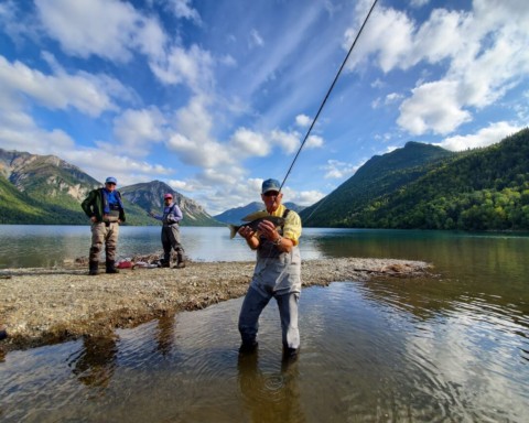 An angler holding a freshly caught arctic grayling